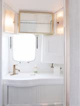 To create a sense of design continuity from the kitchen and living room, the same champagne-bronze hardware is featured in the bathroom.
