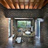 The bathroom has views to the bushland on the cliff. The space is entirely open, with privacy afforded by the remote location and dense vegetation. 