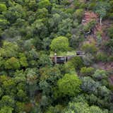 House of the Tall Chimneys is entirely off the grid. Power is generated with solar panels; black and gray water is contained and managed before it’s further filtered by the undergrowth; and potable water is collected from the nearby stream. “More important than these technological fixes, however, is the fact that the building requires very little in terms of resource input in order to function successfully,” says architect Ant Vervoort. “Careful design is probably the most fundamental aspect in designing environmentally sustainable buildings.”