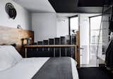 The black cladding of the exterior is echoed internally. The master bedroom also features a ladder that leads to a rooftop bathtub.