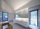 Timber accents in the lofty master bathroom comprise a simple Muji bench and a Hinoki wood soaking tub.