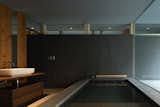 The Japanese bathroom is well lit by many windows. The home's palette of Hokkaido Cedar wood, concrete floors and grey-textured walls is condensed into this intimate space. 