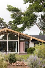 The designers introduced new Alaskan yellow cedar glulam beams for the updated roofline and windows by Pella. The front door is painted in Sherwin Williams "Rose Colored."